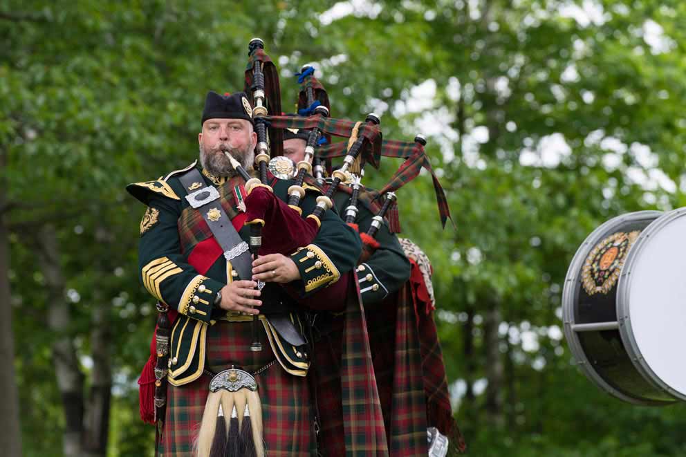 Pipers of the 2nd Battalion of the Royal Canadian Regiment play the bagpipes wearing the Maple Leaf Tartan.