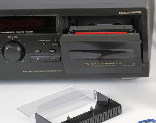 Lecteur-enregistreur de cassettes audio; la porte est ouverte et une cassette est à l’intérieur