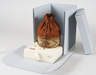 Panier tissé avec une doublure en soie, mis en réserve dans une boîte sur mesure fabriquée avec du carton ondulé sans acide.