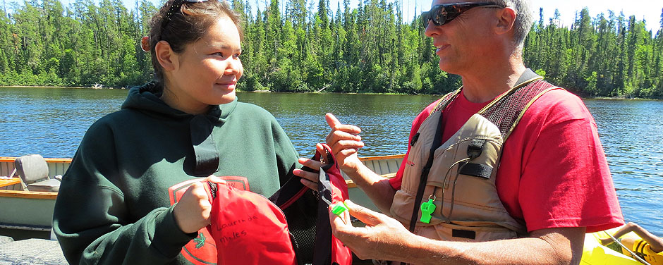 Slide - Junior Canadian Ranger Laurinda Miles of Fort Severn First Nation in Northern Ontario, receives a life jacket from Gordon Giesbrecht 