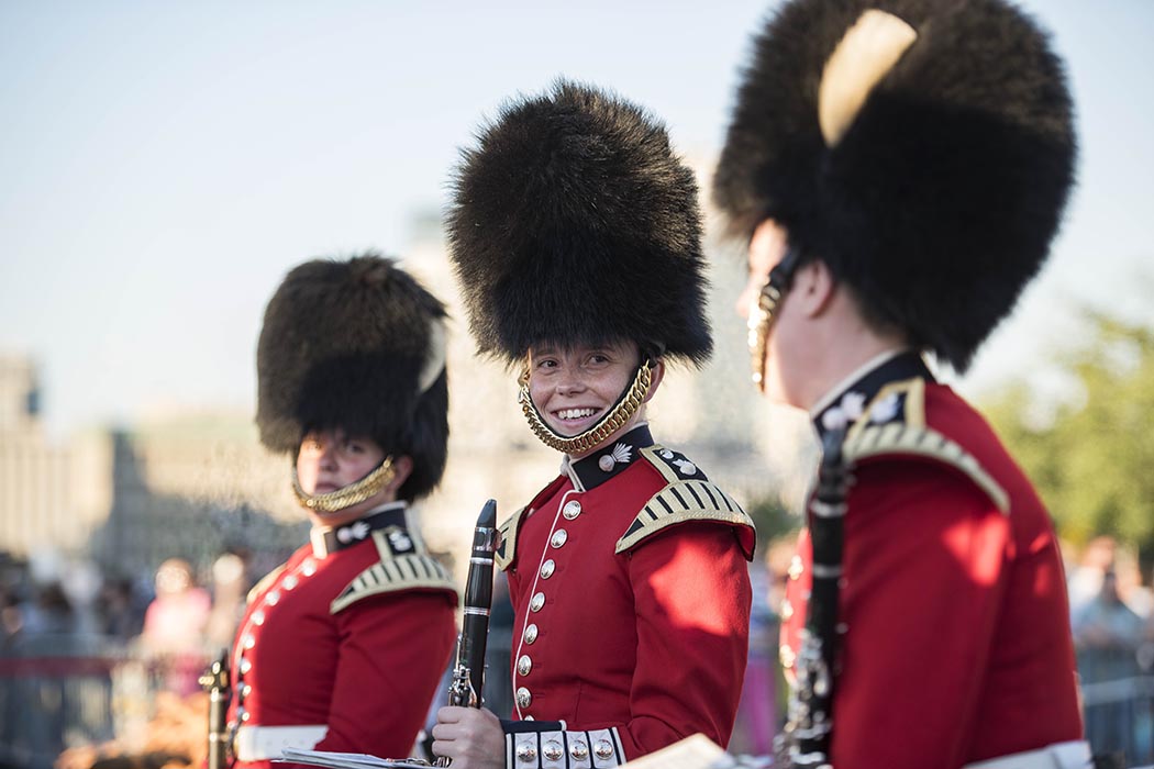 Wearing their famous bearskin hats, female members of the Ceremonial Guard share a moment before performing in Fortissimo on the lawns of Parliament Hill in Ottawa, Ontario in July 2018. Photo: Ordinary Seaman Camden Scott, Army Public Affairs. ©2018 DND/MDN Canada.