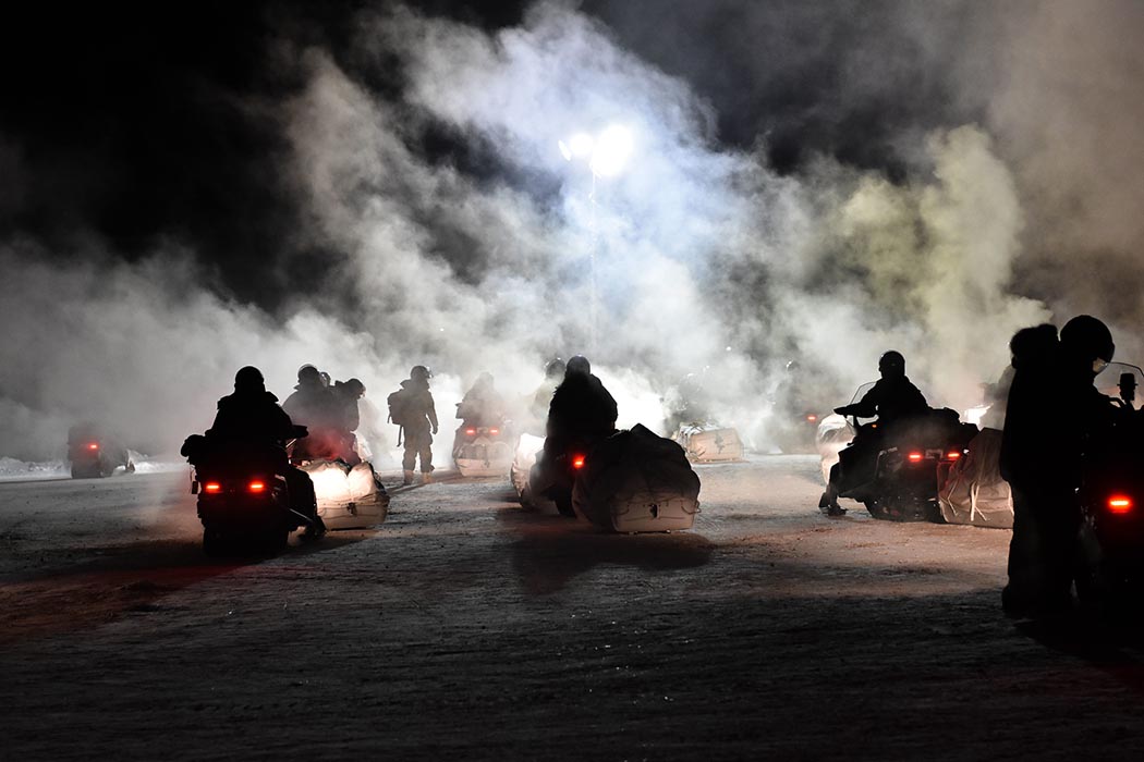 Soliders on snowmobiles at night