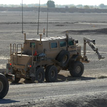 A Buffalo vehicle uses its extendable arm to investigate a possible mine or improvised explosive device.
