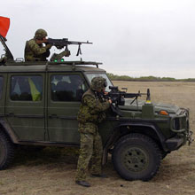 Des soldats montent leurs fusils sur un G Wagon.