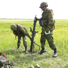 Des soldats chargent un mortier de 81 mm.