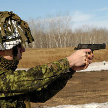 Soldier firing his Browning 9-mm.