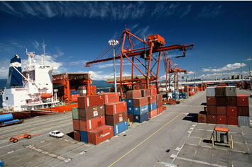 Industrial shipping containers being loaded onto a boat