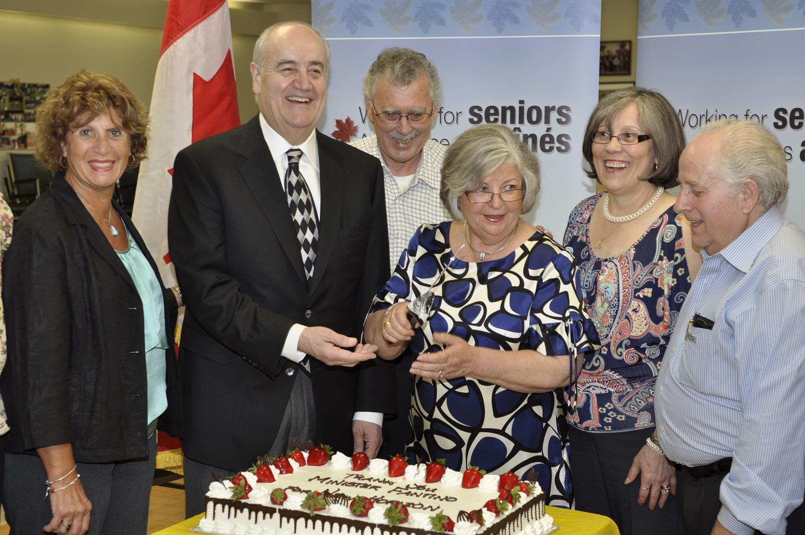 Minister Fantino cutting the cake with event participants.