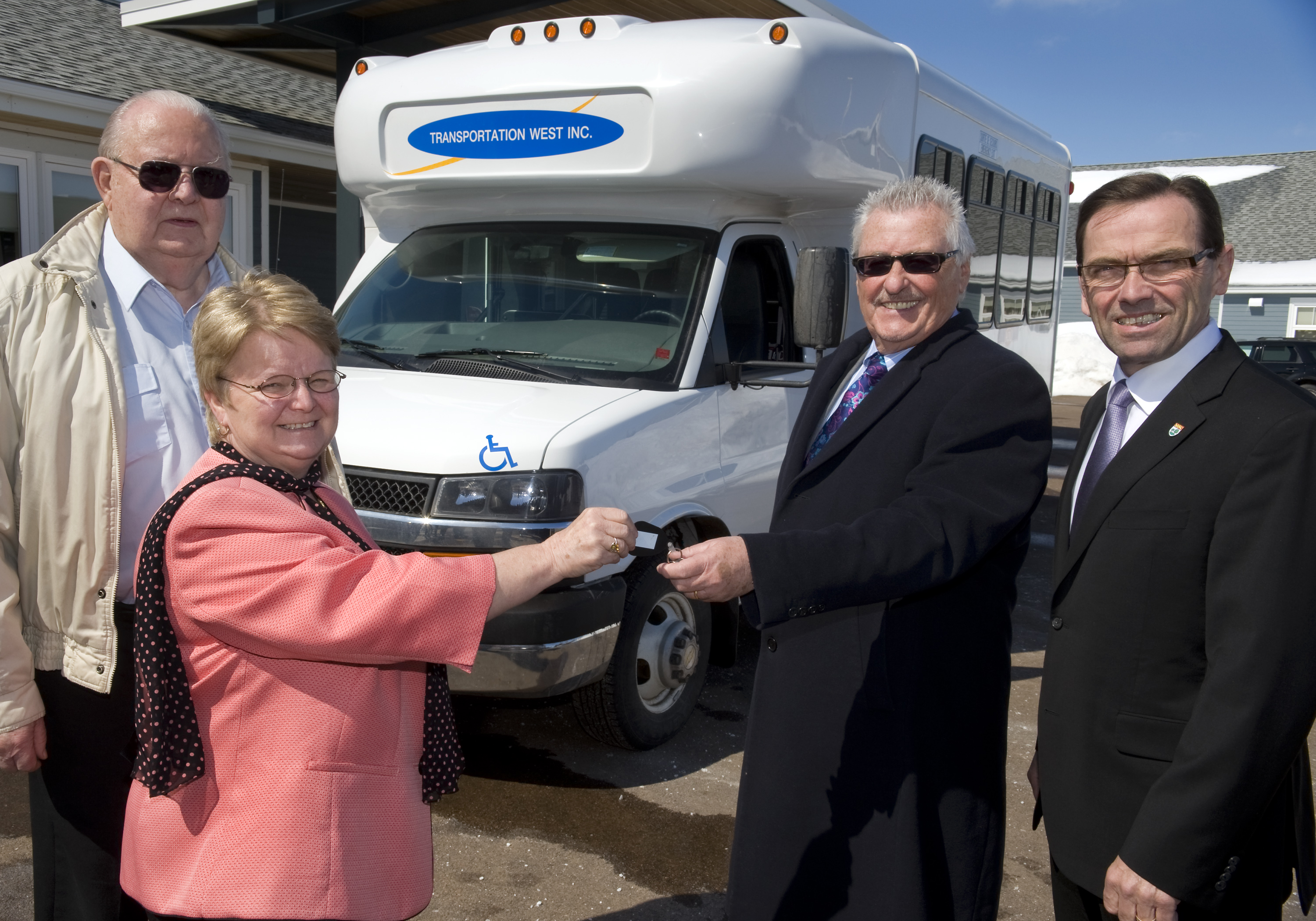 From left to right: Gordon Wooder of Transportation West, Minister Gail Shea, Minister Robert Vessey and Gordon Bush of Transportation West celebrate the delivery of two new buses to Transportation West.