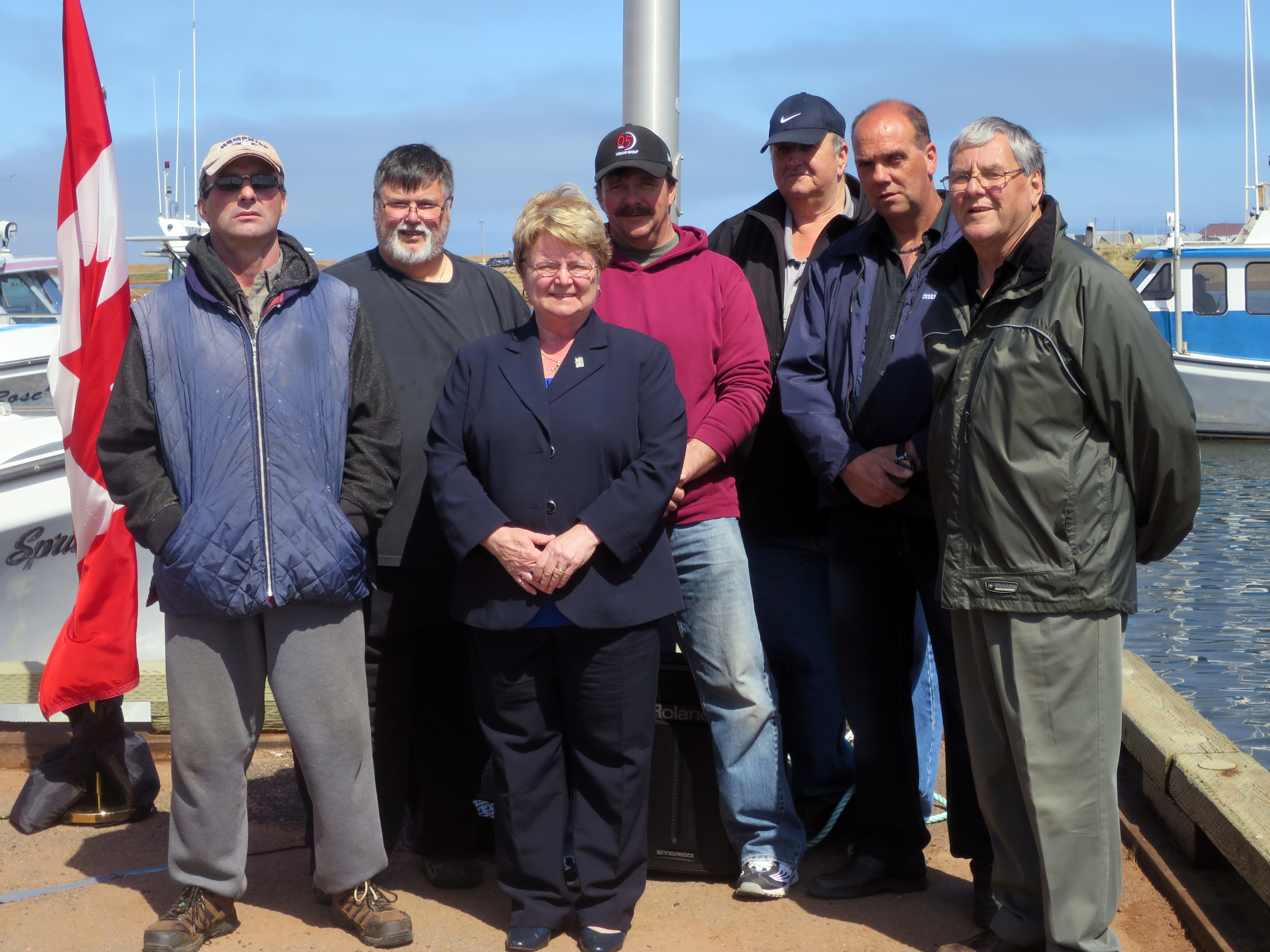L¿honorable Gail Shea, ministre des Pêches et des Océans, et des représentants de l¿autorité portuaire de Judes Point/Tignish après l¿annonce d¿un projet dans ce port. À l¿avant, la ministre Shea. À l¿arrière, des membres de l¿autorité portuaire : Glen Desroches, Brian LeClair, Kenneth LeClair, Earl McGrath, Michael McInnis, président, et Russell Gallant, gestionnaire. Le projet comprend la reconstruction partielle d¿un quai, la construction d¿un prolongement d¿un quai et la construction d¿un mur pour protéger le littoral.