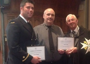 The Honourable Frank F. Fagan, CM, ONL, MBA, Lieutenant Governor of Newfoundland and Labrador, presents Coast Guard employees Chief Officer Brock Thimot (L) and Cook/ Seaman Paul Ivany (center) with St. John Ambulance national Certificates of Commendation in recognition of their life-saving efforts while serving aboard the CCGS Vladykov. 