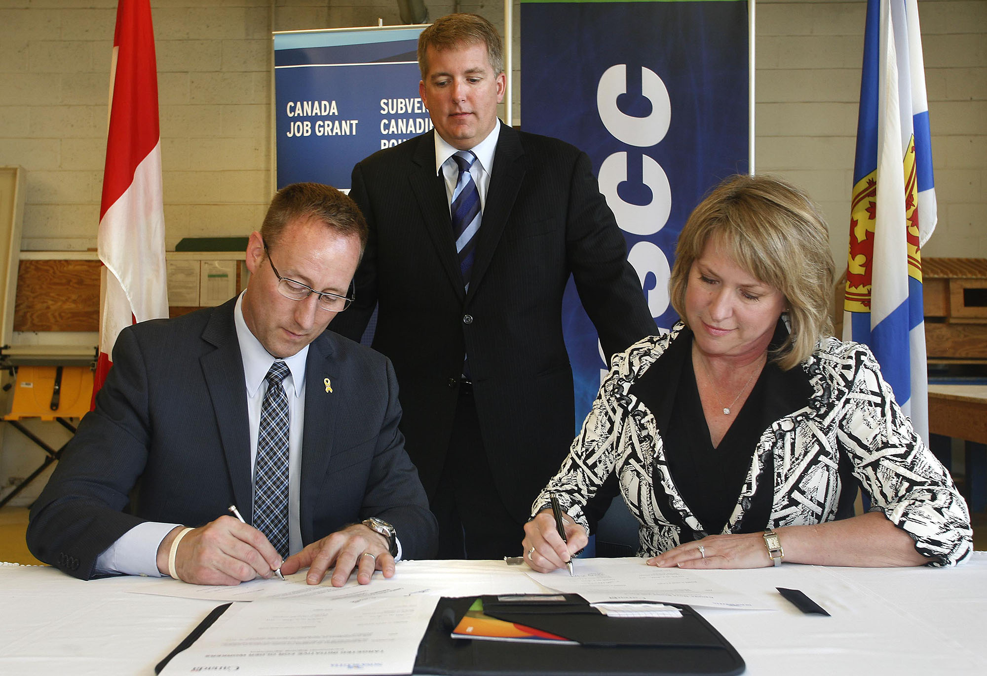 Minister MacKay, Minister Regan, and Parliamentary Secretary to the Minister of Employment and Social Development, Scott Armstrong, finalize agreements to help Nova Scotians get jobs.