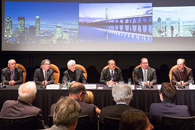 Minister Lebel, surrounded by some members of the architectural committee, answers questions from the media on the design for the New bridge for the St. Lawrence. (From left to right: Douglas Balmer, Arup; Claude Provencher, architect, Provencher Roy; Poul Ove Jensen, architect, Dissing+Weitling; the Honourable Denis Lebel, Minister of Infrastructure, Communities and Intergovernmental Affairs and Minister of the Economic Development Agency of Canada for the Regions of Quebec; Marc Brazeau, Director General of the New bridge for the St. Lawrence corridor project, Infrastructure Canada; Glen Carlin, Interim Chief Executive Officer, The Jacques Cartier and Champlain Bridges Incorporated)