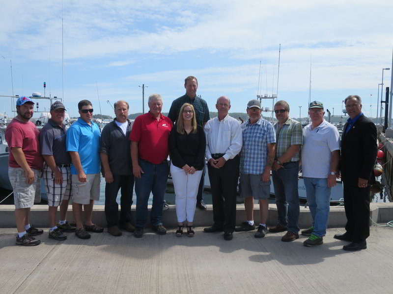 The Honourable Peter MacKay, Regional Minister for Nova Scotia, Minister of Justice and Attorney General of Canada, and representatives of small craft harbours and of Northumberland Ferries Ltd., discuss the incredible potential of harbours to bolstering the local economy and pose for a photo following an announcement at Caribou Ferry. In the back, Minister MacKay. Front row, from left to right: Randy Burns and Kevin Pye from Sonora Harbour Authority; Mark Boyd from Cribbons Point Harbour Authority, David MacCarty and John Lakenman from Caribou Ferry Harbour Authority; Karla MacFarlane, MLA for Pictou-West; Mark MacDonald, President and CEO of Northumberland Ferries Ltd.; Bruce Jack, Ted Stevens and Don Dodge from Port Bickerton East Harbour Authority; and Colin LaVie, MLA for Souris, PEI.
