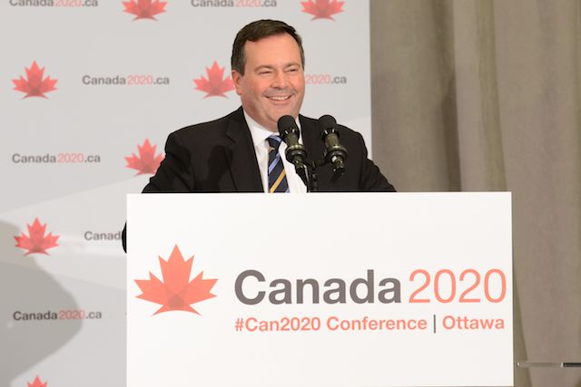 Le ministre Kenney  prononçant son discours au lutrin.