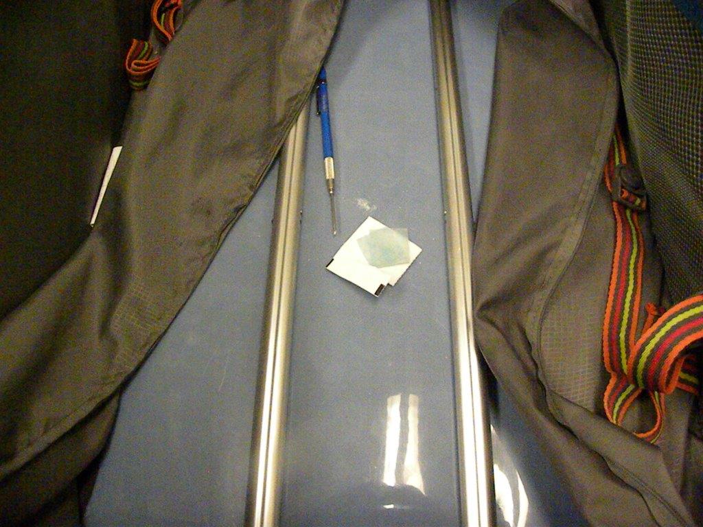 Incision dans le double fond de la valise faite par l¿agent des services frontaliers et laissant apparaître la drogue dissimulée 