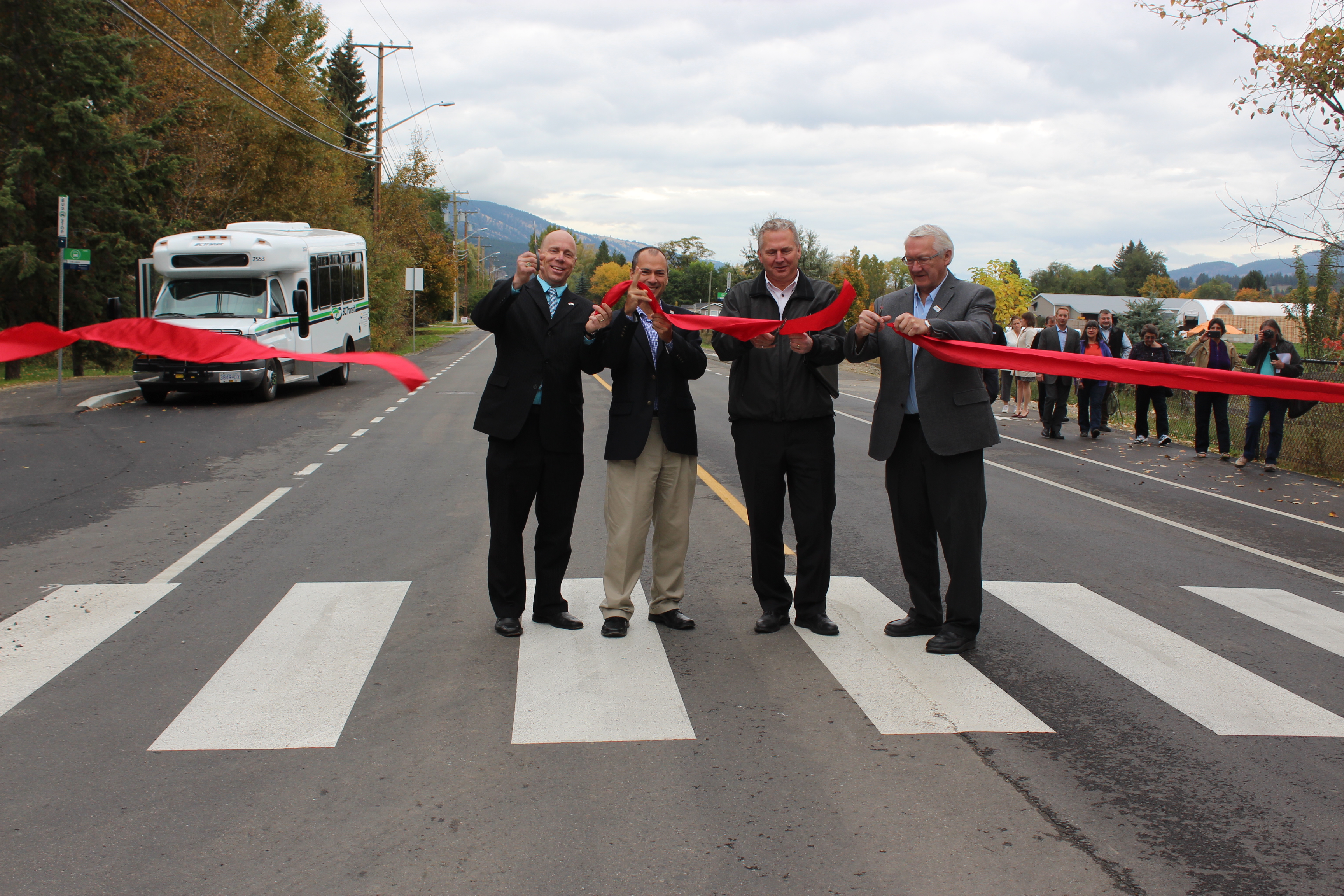 From left to right: Ron Cannan, MP for Kelowna-Lake Country,  Norm Letnick, MLA for Kelowna-Lake Country, David Dean, Road Safety Engineer for the Insurance Corporation of British Columbia, and James Baker, Mayor of the District of Lake Country, cut the ribbon to formally re-open Bottom Wood Lake Road and celebrate the completion of this important road restoration and active transportation upgrade project.
