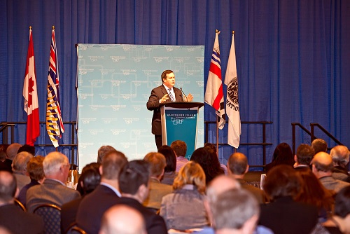 Le ministre Kenney prononçant son discours au lutrin.