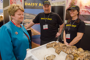 The Honourable Gail&nbsp;Shea, Minister of Fisheries and Oceans, and Raspberry Point Oysters representatives at the Seafood Expo North America&nbsp;2015 (left to right: James&nbsp;Power, Manager; Karen&nbsp;Power, Sales).