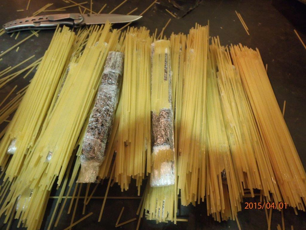 Bags of pasta revealing a cellophane wrapped flat package of brown substance suspected to be opium.

