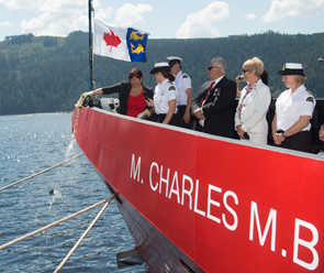 Sheila Charles, granddaughter of Martin Charles breaks the traditional champagne bottle over the bow of CCGS M. Charles M.B. as (R-L) Captain Joanne McNish, Clifford Charles, Senator Nancy Greene Raine and Commanding Officer of the M. Charles M.B. Nichola Mancey.