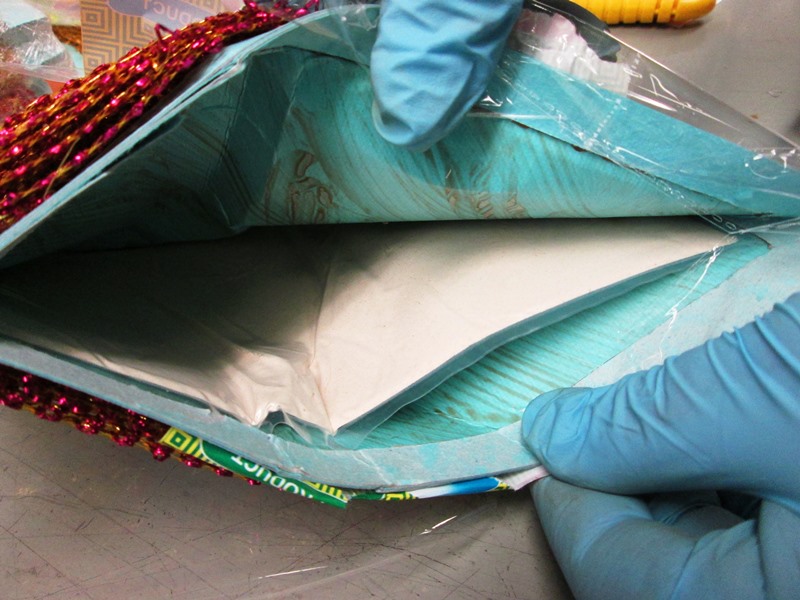 Opening of the sides of the ribbon parcel and discovery of heroin