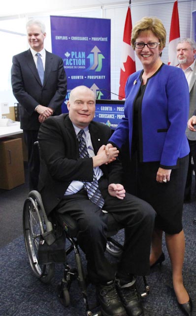 Minister Finley shaking hands with Mr. Gary Birch, a panel member.