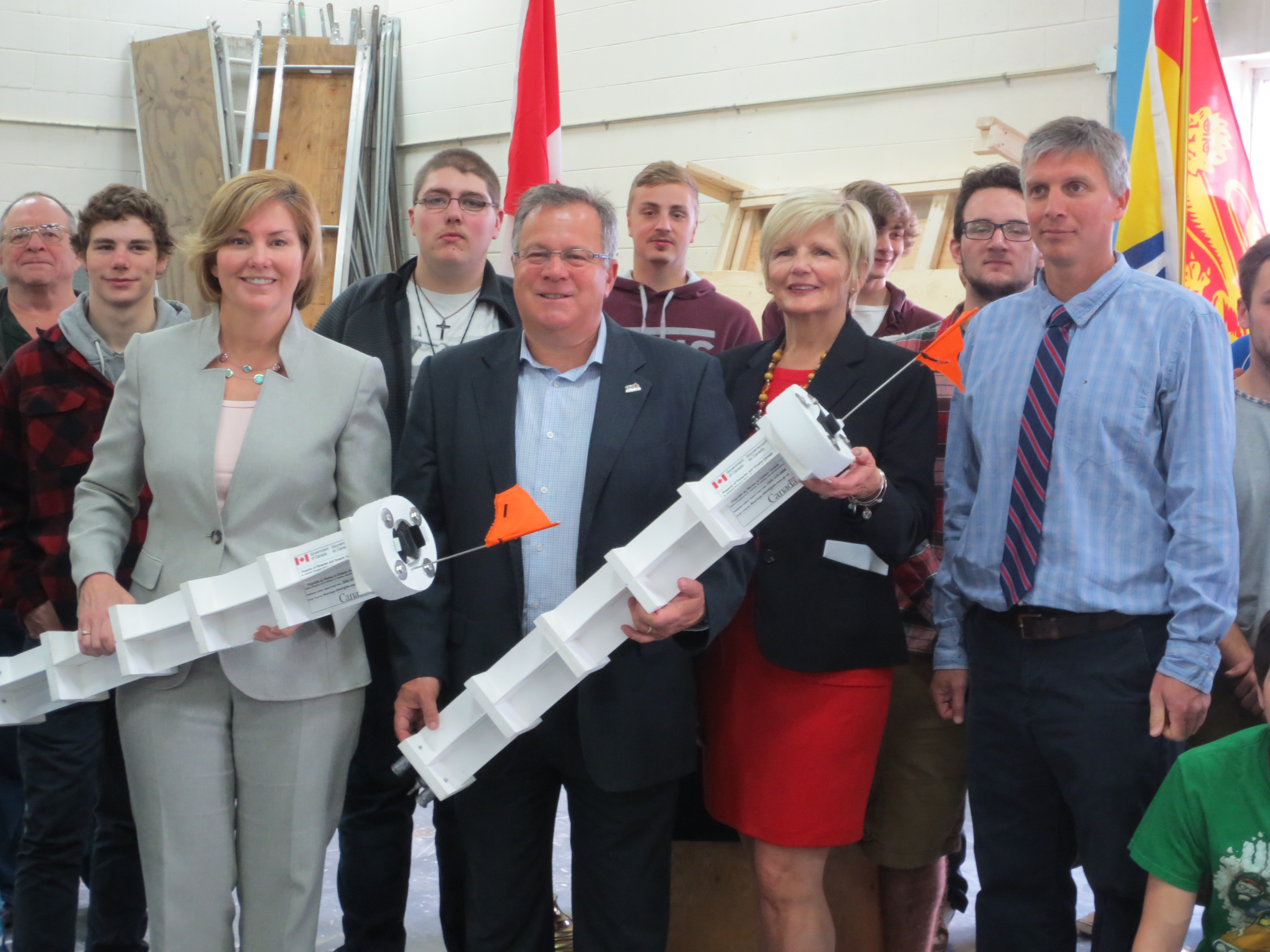 Fundy High School shop students built ocean current-tracking devices that provide valuable data for aquaculture research under a collaborative project with Fisheries and Oceans Canada, the NB Department of Agriculture, Aquaculture and Fisheries, as well as the Atlantic Canada Fish Farmers¿ Association. Students are seen here with (from left to right) MP Karen Ludwig, Minister Rick Doucet, Susan Farquharson and teacher Cush Thompson.