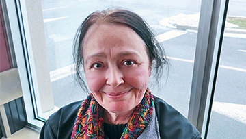 Head and shoulders of a woman wearing a scarf and a CCGS Ann Harvey jacket.