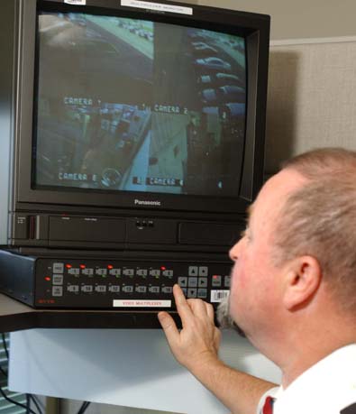 Agent de sécurité observant un écran à un station de surveillance.