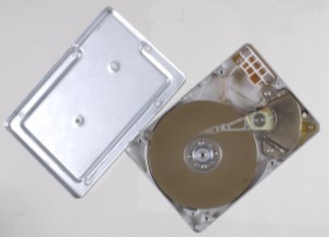FBoîtier argenté de disque dur ouvert; on y voit le plateau rigide et d’autres composants mécaniques