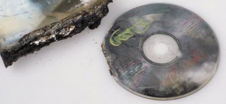 CD audio et boîtier de CD partiellement noircis et dont la périphérie a fondu à la suite d’un incendie