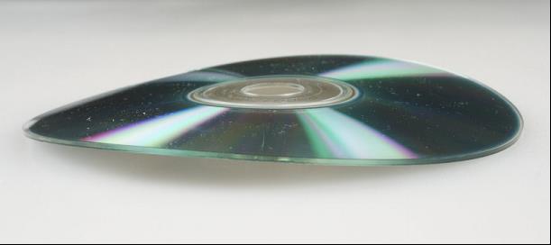 Recordable CD that is warped and not lying flat on a horizontal surface