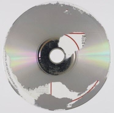 Vue du dessous d’un CD audio dont la couche métallique est corrodée