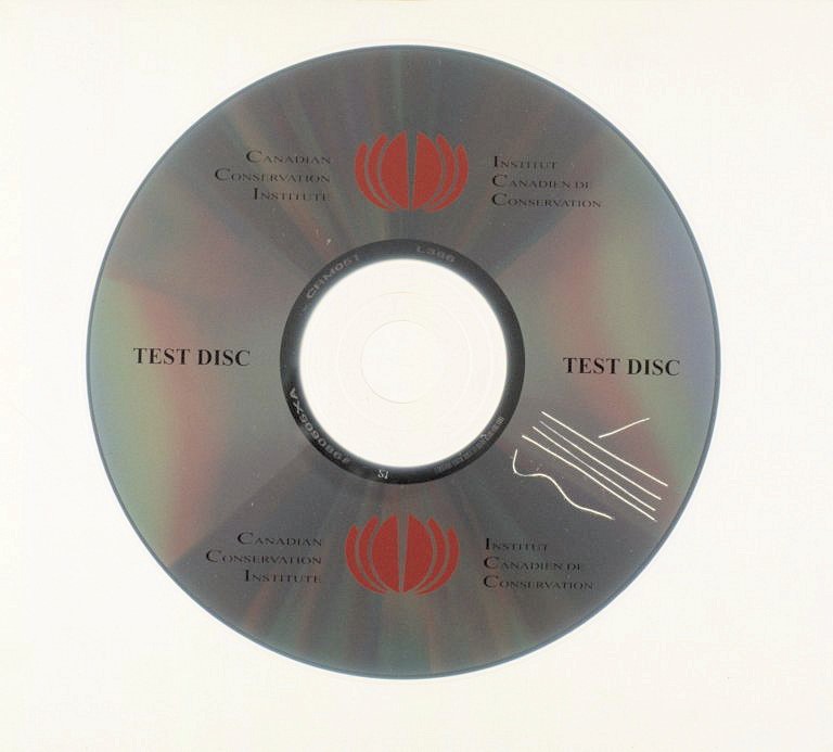 Label side view of an audio CD showing a group of scratches that have damaged the metal layer