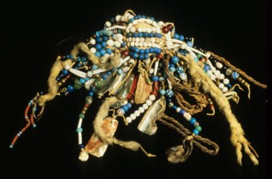 Petit objet fait de nombreux rangs de perles, de ficelles de fourrure et d'autres décorations.