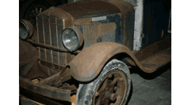 A historic vehicle with many of its iron components covered with rust.