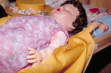 Une substance pulvérulente blanche est visible sur le bras d'une poupée en PCV.