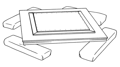 Four padded blocks placed at 45° angles under each corner of the frame lift the frame and its painting off the table surface.