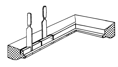 Un ciseau à bois est placé le long de la ligne marquée afin d'approfondir l'incision; un autre ciseau à bois est placé en diagonale, créant de petites sections dans la partie à enlever.