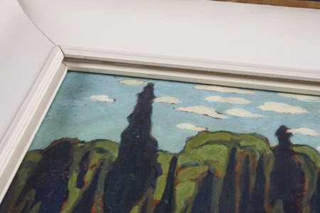 Photographie du coin supérieur gauche de la même peinture montrant l'entretoise de bois, rembourrée à l'endroit où elle touche la surface de la peinture.