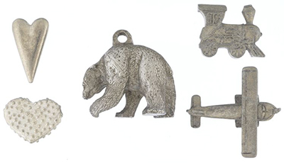 De gauche à droite : deux petits jouets en forme de cœur, un pendentif en forme d'ours et des figurines : une locomotive et un avion
