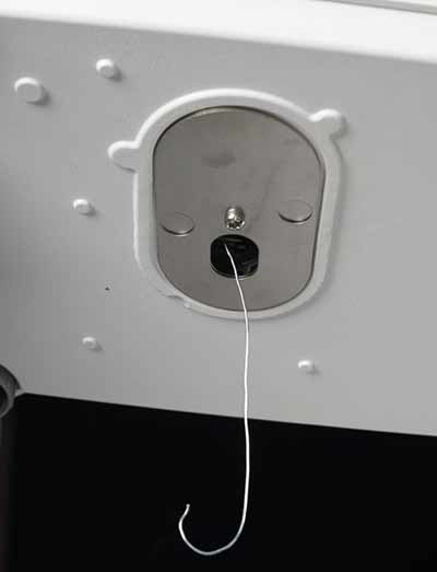 Detail of wire bent into hooks at either end. The top end of the hook is attached to another hook inside the balance.