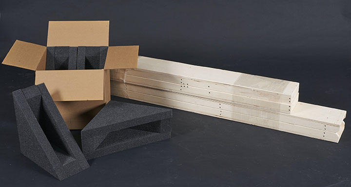 The disassembled channel crate components: foam pads in corrugated carton on the left; channel sections on the right