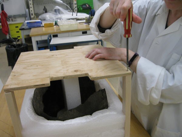 A person installing a cover on the mount and insert assembly.