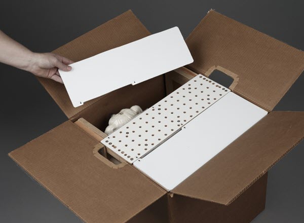 A person places protective covers over the restraint system in the box.