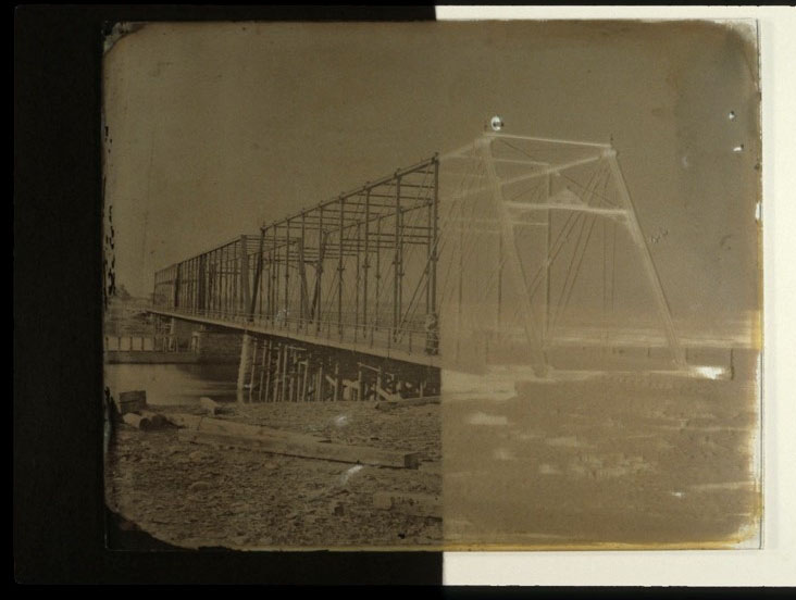 Collodion glass plate negative with black paper underlay on left half of image depicting a metal bridge