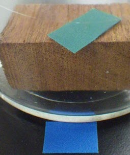 Pot en verre contenant une bandelette détectrice d’acide et une pièce de bois