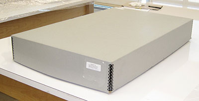 A store-made laminated paperboard box with reinforced metal edges.