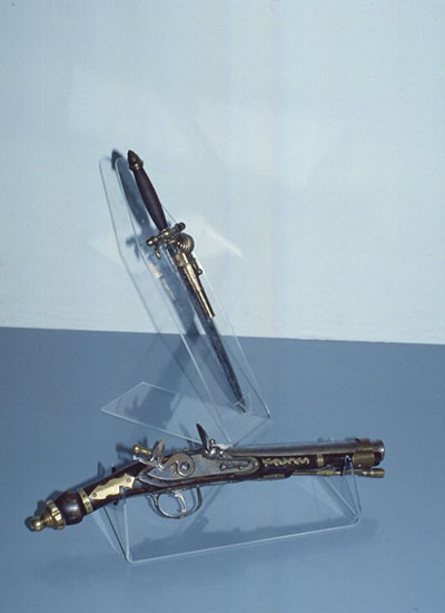 Acrylic sheets supporting a gun and a knife.